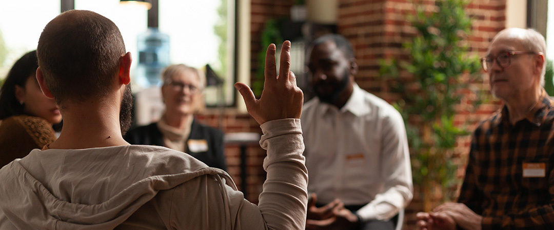 Man raising his hand in a group session.