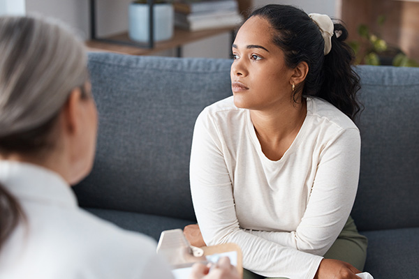 Woman looking off in the distance while in a therapy session.